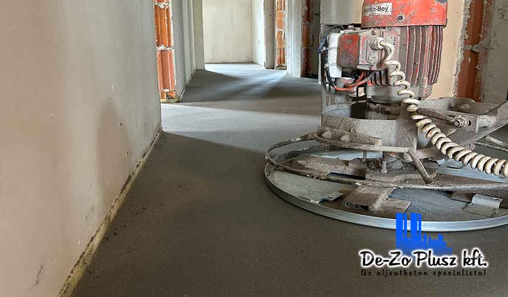 Rotációs gép estrich beton simításához, frissen elkészült aljzatpadlóval, burkolás előtti felületkiegyenlítéshez.